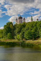 Fototapeta na wymiar Domes of the monastery are reflected in the lake of Theophany Park. Kiev, Ukraine