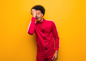 Young sport black man over an orange wall tired and very sleepy