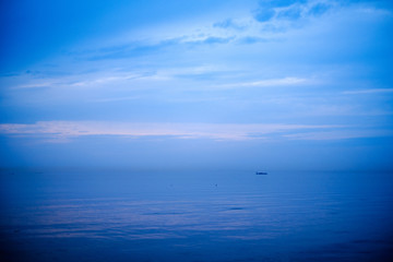 calm sea beach on the shore of Baltic sea with blue clouds and low tide