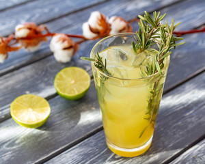 Yellow rosemary drink in a glass on the table