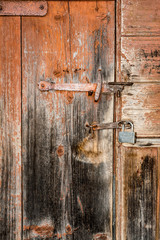 element of an old wooden door with a metal handle and padlock