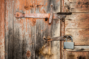 element of an old wooden door with a metal handle and padlock