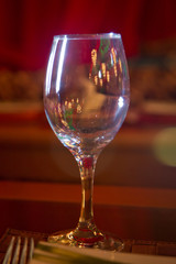 Empty wine glass. Tableware on table in cafe, focus on wineglass stem . Elegant table setting . Bakal