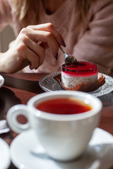 female eating testy pink jelly cheesecake. harmful lifestyle and eating concept