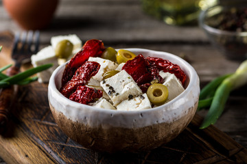 Greek cheese feta with herbs and olives, sundried tomatoes. Bulgarian cheese. Feta in oil. Olove oil. selective focus. appetizer
