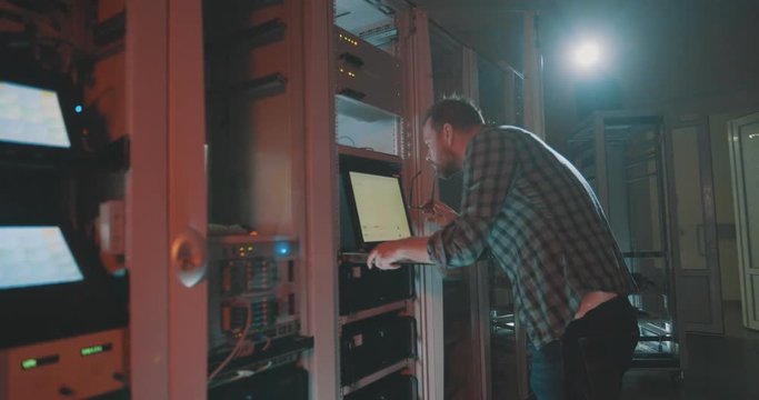 Young programmer coding in server typing on laptop