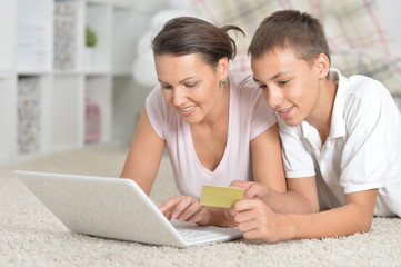 Close-up portrait of mother and son using laptop, online shopping concept