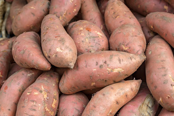 An abundance of sweet potatoes for sale on a market stall