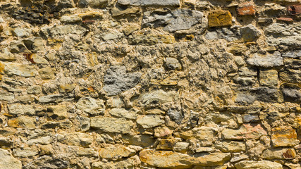 Background of old stone wall. The texture of the stone surface. Brickwork in the old European city. Pattern in retro style