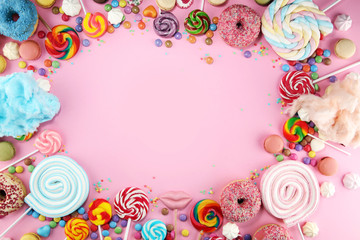 candies with jelly and sugar. colorful array of different childs sweets and treats on pink