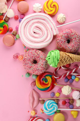 candies with jelly and sugar. colorful array of different childs sweets and treats on pink