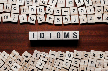 Idioms word concept on cubes - obrazy, fototapety, plakaty
