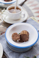 Traditional Russian cake with cocoa in the shape of a ball. Served breakfast table. Reflection of light in a mug of tea. Cozy morning at home.