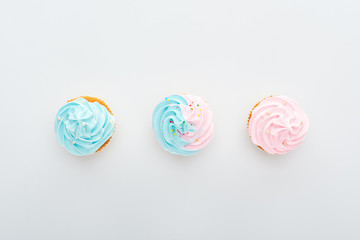 top view of delicious colorful cupcakes with sprinkles in row Isolated On White