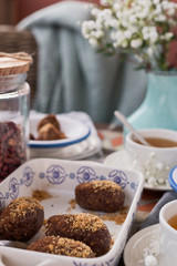 Traditional Russian cake with cocoa in the shape of a ball. Served breakfast table with mugs of tea and dessert. Morning light on the photo.