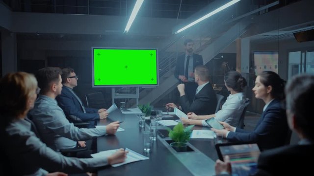 Late at Night In the Corporate Meeting Room: Director Talks and Uses Digital Chroma Key Interactive Whiteboard for Presentation to Executives, Investors. Green Mock-up Screen in Horizontal Mode