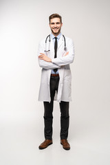 Full length young medical doctor on white background.