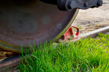 red brake shoe under the wheel of a freight car on the siding