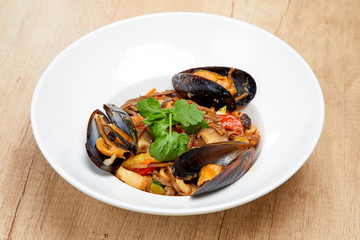 mussels with buckwheat noodles on the wooden background