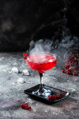 red cocktail with ice vapor. Cocktail with smoke. Alcohol drink, vodka, ice, party, dry ice.