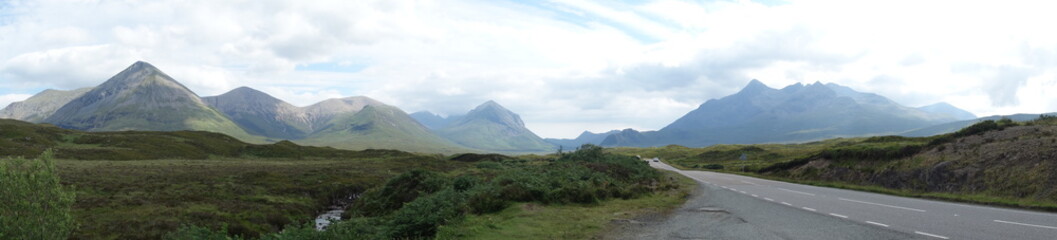 Fototapeta premium Long Panorama of a mountainous landscape with clouds, Isle of Skye Scotland