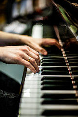 hands playing the piano at a concert © Roberto