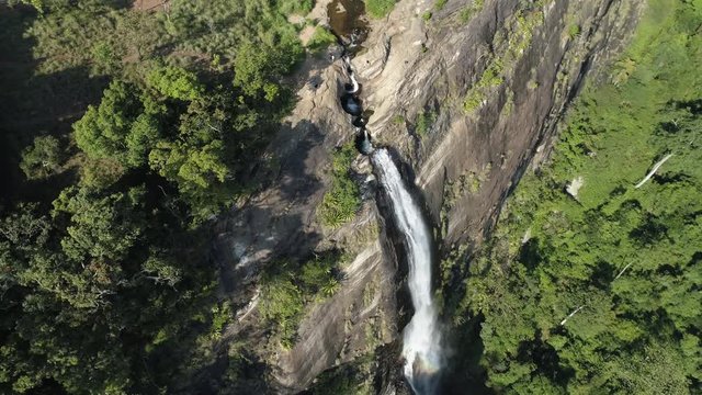 Diyaluma Falls, Aerial pan as water crashes out over cliff to lush jungles of Sri Lanka below