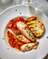 Squid stuffed with tomatoes and grilled bread plate Italian comfort food.