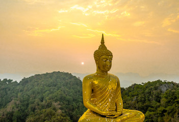 Obraz premium Golden Buddha statue on the top of the Wat Tham Sua or Tiger Cave Temple in Krabi province. Sunset sky