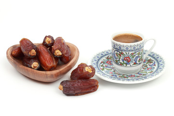 Islamic festival of Ramadan concept. With a delicious tropical dates on a bamboo plate and Turkish coffee on a isolated white background. Traditional Middle East culture. Ramadan Kareem.