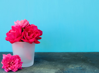 Pink rose flower arrangement with bright blue background, copy space for celebration concept.