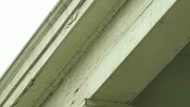 Damaged Wood Moulding on Porch Roof with American Flags DOLLY LEFT SLOW MOTION