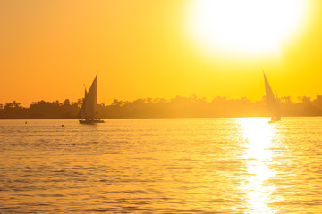 View of the Nile river with sailboats at sunset in Luxor, Egypt