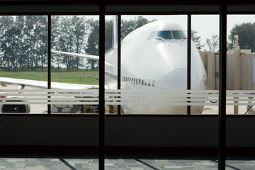 Preparation of the aircraft before flight, ready for loading passengers through  boarding bridge. View of the airplane from the window of the airport building