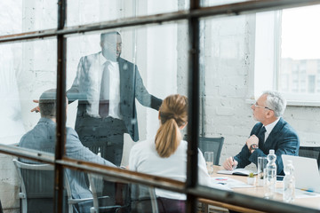 selective focus of african american business coach talking and gesturing near coworkers