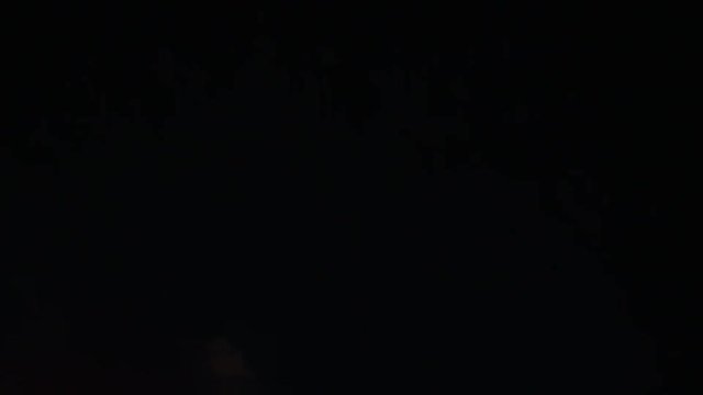 Green and Red Fireworks Exploding in Night Sky TILT UP