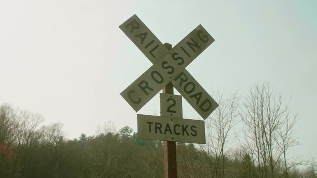 Railroad Crossing Sign with Sun Shining From Behind SLIDE RIGHT