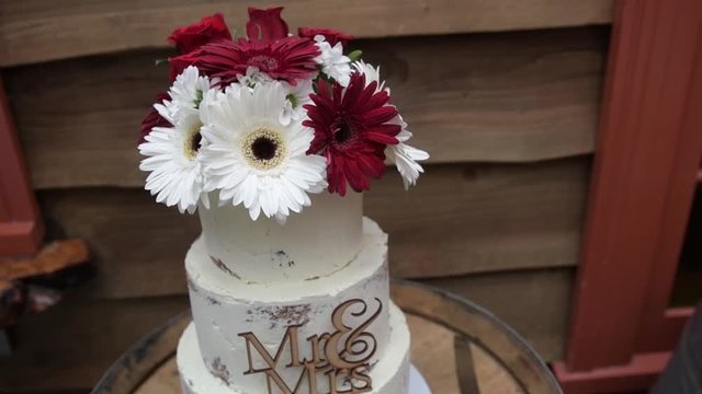 A beautiful wedding cake with Mr. and Mrs. decoration and a flower bouquet on top.