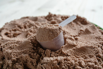 Product photograph of spoon or measuring scoop of whey protein. Whey protein powder sports...