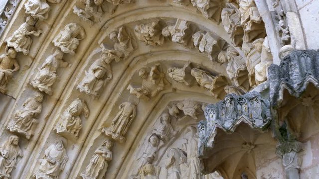 Detail of the archivolts of the Saint Pierre Cathedral. Poitiers. France. Moving camera. Low angle shot