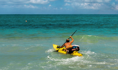 Lifeguard floats in a kayak to rescue  man