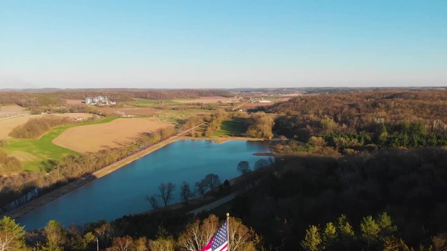 Aerial reveal of an American flag with a beautiful lake view in the background