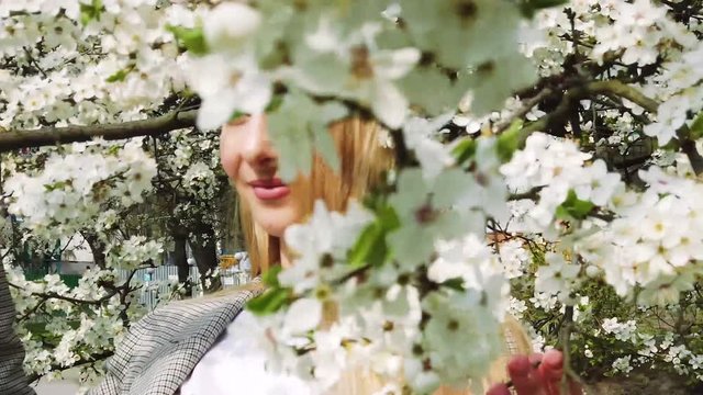Beauty young woman enjoying nature in spring , Happy Beautiful girl in Garden with blooming trees. Slow motion video shooting by handheld gimbal