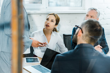 cropped view of business coach standing in conference room near coworkers