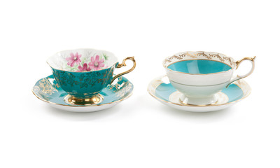 High resolution close-up of two beautiful antique tea cups with saucers isolated on a white background.