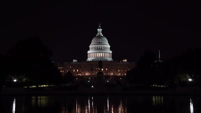 US Capitol Building and reflecting poll at night.