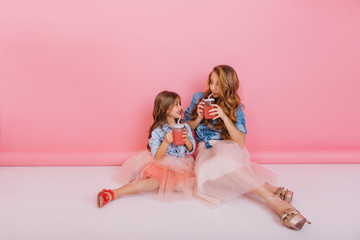 Trendy mom and daughter drink freshly squeezed cherry juice through the tubes, waiting for guests...