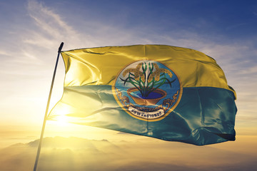 Ang Thong province of Thailand flag waving on the top sunrise mist fog
