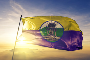 Uthai Thani province of Thailand flag waving on the top sunrise mist fog