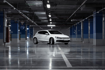 Exterior of white modern sport car at parking at evening time.